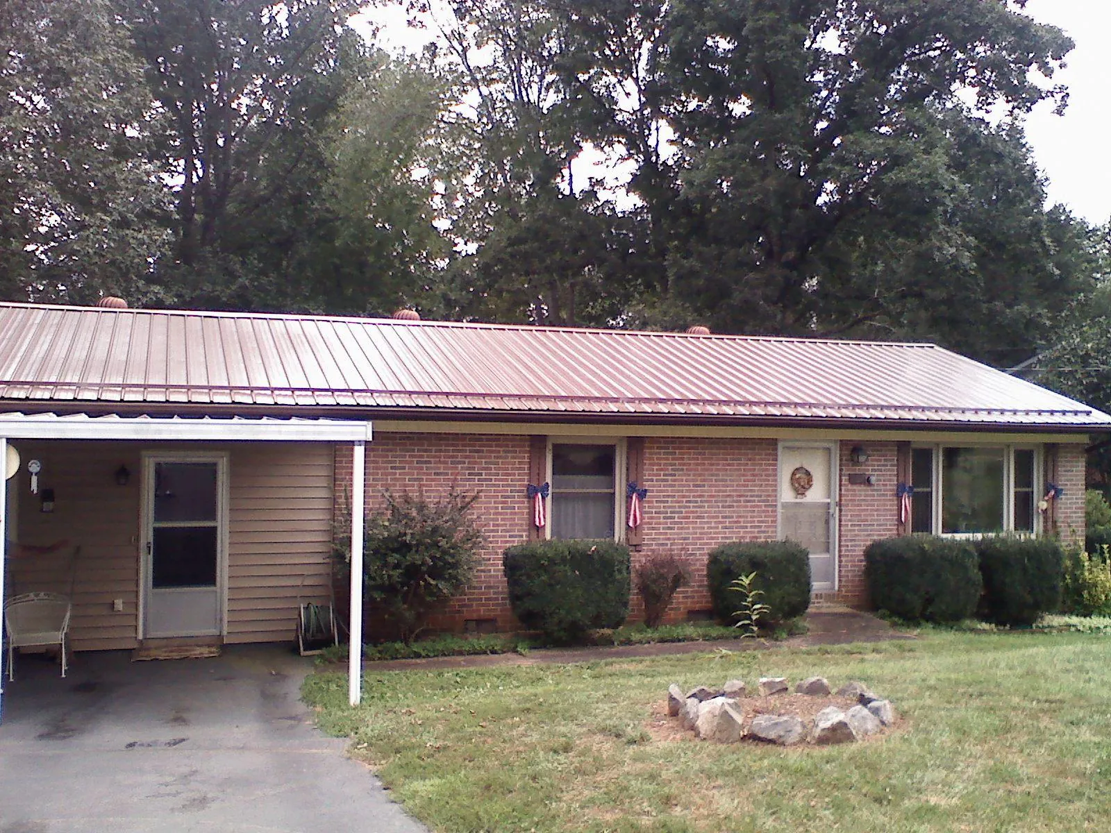 Bronze metal roof and carport on a brick ranch home — Roof Repair work by our crew in Pocomoke City